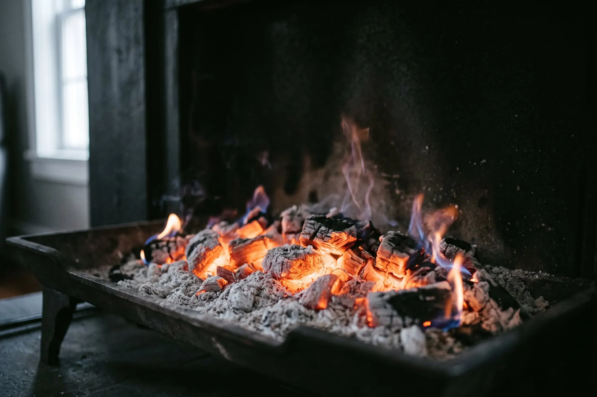 A bed of glowing orange embers and pale ash