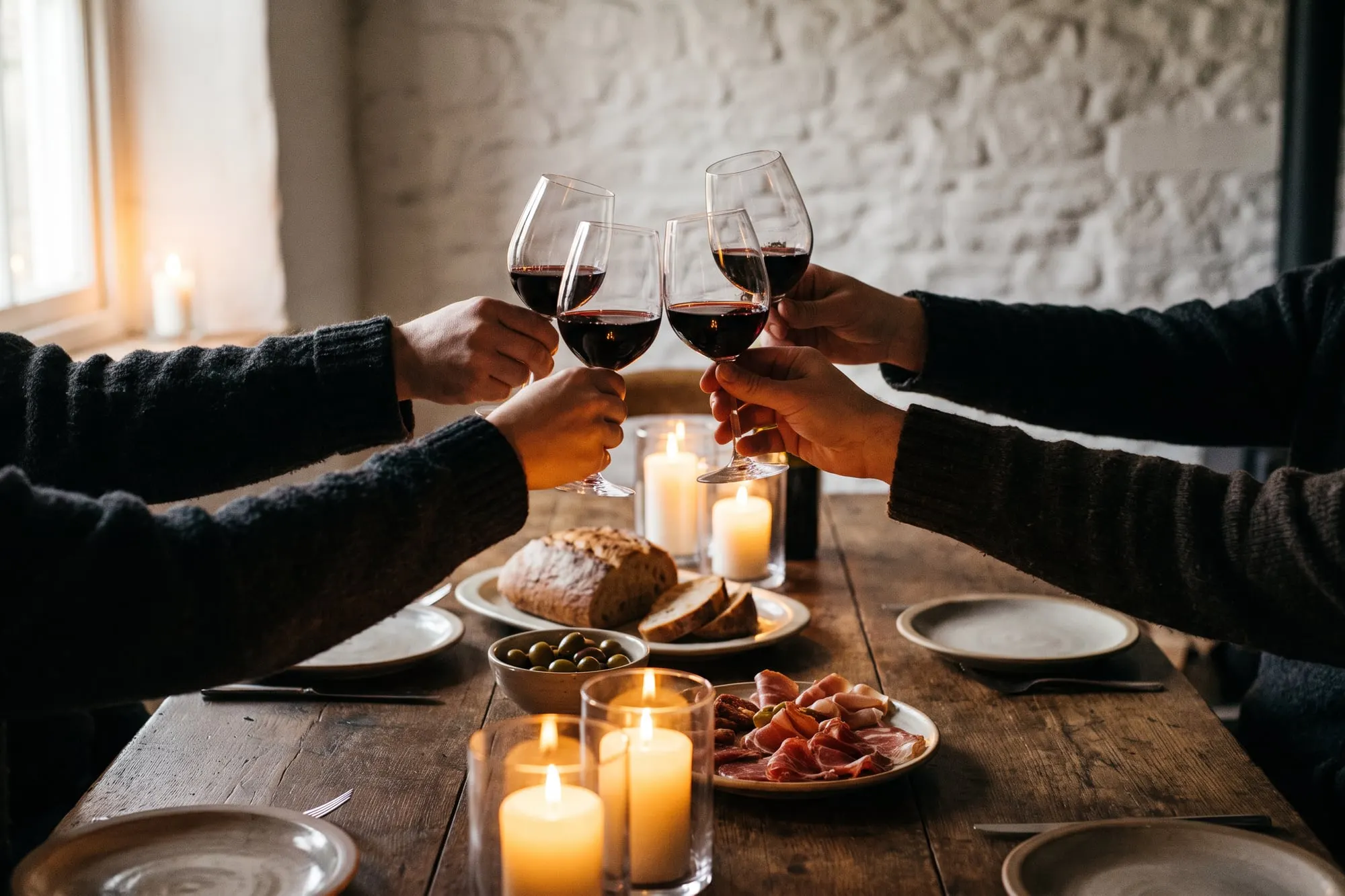 Guests seen from behind raising their glasses over dinner